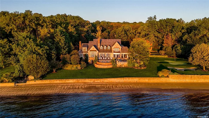 Overlooking picturesque Oyster Bay Harbor, this stately waterfront Manor home is located on 1.71 acres and boasts 245 feet of water frontage. Featuring 6 large bedrooms with walk-in closets and 7.5 baths with high-end fixtures and fittings, this magnificent property has an idyllic master retreat on the main floor with incredible views across the Harbor, 2 spacious walk-in closets with center islands, and a luxurious marble master bathroom with a soaking tub and an incredible shower for two.  The foyer, with its grand mahogany entry doors and fielded wainscot paneling, leads to an open-plan bright and airy great room with a dramatic two-story ceiling, floor-to-ceiling stone fireplace, clerestory windows, and 3 sets of French doors that frame stunning water views. With herringbone floors, built-in cabinetry that offers ample storage, and glass doors for displaying china, the elegant dining room is perfect for gracious entertaining. The chef&rsquo;s kitchen has been designed with custom cabinetry, professional-grade appliances, 2 walk-in pantries, marble counters, an expansive marble center island with inlaid walnut butcher-block ends, and an octagonal breakfast area that overlooks the shore. A lovely conservatory/sunroom with terracotta flooring and a fireplace is located off the kitchen and offers an ideal spot for relaxing.  The lower walk-out level features a paneled family room with a fireplace and coffered ceiling, a billiard room, temperature-controlled wine cellar, exercise room, custom onyx wet-bar, and an amazing home theater with a coffered ceiling, comfortable leather seating, and sound-proofed walls. The exterior has a generous bluestone patio, outdoor kitchen, and an incredible infinity pool in a beachfront setting with professional landscaping, manicured formal gardens, yoga platform, and a putting green. Additionally, there is a charming guest suite with a bedroom, bathroom, kitchenette, living and dining area. Complete with 6-zone central air conditioning and 15-zone heating systems, in-ground sprinklers, a 2-car garage, this exceptional Smart Home is the epitome of timeless design and showcases exquisite architectural details with extraordinary craftsmanship throughout.