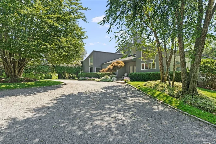 This modern Quogue oasis sits on over 2.2 acres of land, making it the ideal year-round home. The open floor plan, hardwood floors, vaulted ceilings and copious amounts of windows invites an abundance of natural light, bringing a sense of both peace and energy. Latest amenities include a tremendous chef&rsquo;s kitchen with marble center island, dual Wolf ovens, Sub-Zero refrigerator and wine cooler for the food and wine enthusiast. A large living room with fireplace and separate den are perfect spots for relaxing or entertaining, while the breakfast nook offers plenty of sunlight and greenery. The first floor features 3 bedrooms and 3 baths offered as junior suites, while the primary suite is located on the second floor. Enough space for everyone to have their own privacy and come together for social time. Outdoors is a heated pool, hot tub and all-season tennis court. The pool house has a living space with changing room, bath and kitchenette. This is all surrounded by stunning landscaping that offers privacy and serenity, a true gem.