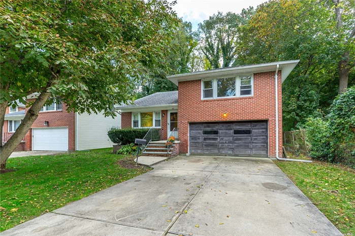 Spacious, solid brick split level house conveniently located near shopping on a quiet dead end street. living room, dining room and eat in kitchen with access to big, beautiful private backyard. All large rooms, Upper Level - primary bedroom, hallway bath, 2 additional bedrooms, walk up attic, hardwood floors throughout. Lower Level - office/sunroom access to backyard, full bathroom and laundry room. Additional, huge lowest level with unfinished space currently used for storage. full size attached 2 car garage.