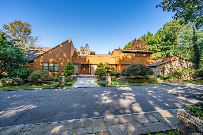 This cedar and stone home resonates a feeling of serenity, clarity and light as each and every window takes in the entire expanse of the landscape. Richly appointed with oak flooring, soaring ceilings, an open floor plan and walls of windows. The open layout features a dramatic great room, inviting den, formal dining room and a separate wing that&rsquo;s ideal for long term guests or a home remote office. Coveted main floor primary suite with three additional bedrooms on the second level and another on the main level. The two acre property boasts an entertainment complex with an inground pool, tennis court and an expansive patio surrounded by mature gardens. Generous cabana is ideal for summer entertaining. Golf, equestrian trails, the beach, the Tilles Center for the Performing Arts and the famed Americana shopping center are conveniently located nearby. Only 25 miles from NYC. Jericho SD.