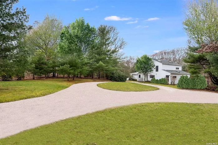 Sited on a sprawling 1.62+/- acre parcel in Northwest East Hampton, this spacious Contemporary is conveniently near Cedar Park, Sammys Beach, and the renowned villages of Sag Harbor and East Hampton. Featuring 3 bedrooms and 3.5 baths, the open floor plan features a living and dining room with vaulted ceiling, wet bar, and fireplace, a kitchen with stainless appliances, and an all-season sunroom leading to an expansive back deck with open lounge and dining areas that overlook a sparkling heated pool. The first level also includes two ensuite bedrooms. The second level provides a Primary ensuite bedroom with a large closet. Property grounds include mature landscaping which ensures privacy and comfort as well as a circular drive. Additional amenities include hardwood floors, a sauna, a second-floor balcony, and a finished lower level with an egress window. .Listing ID:907395