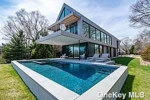 This stunning modern home designed by renowned Architecture firm Stelle Lomont Rouhani. Is truly a work of art, blending function and form seamlessly? Perfectly designed to maximize the spectacular water views from nearly every room in the home, while still offering an abundance of privacy. Comprised of 4 Bedrooms with 3 Full and 1 Half Bath. This elegant home is filled with natural light especially in the open-air vaulted ceiling living room with a private balcony and top-of-the-line kitchen. There is also a built-in wine refrigerator and laundry room. The first-floor master suite overlooks the heated Gunite pool and spa as well as offers breathtaking open water vistas.
