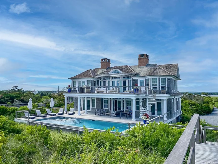Escape to summer bliss at this exquisite new construction, oceanfront home in Quogue, offering unrivaled vistas of the ocean and bay. Nestled on Dune Road, this 2021 traditional build was a collaboration masterpiece by George Vickers, Jr. Enterprises, Austin Patterson Disston Architecture & Design, and Jen Going Interiors. Step into the foyer and discover the elegantly furnished living room, complete with a flat screen Frame TV and a wet bar boasting two dishwashers, a sink, double drink drawers, and an ice maker. Revel in the views of the back deck and pool, creating the perfect entertainment haven. The first level boasts three bedrooms and two full baths, including an oceanfront ensuite bedroom with direct access to the pool deck. Ascend to the second story and be captivated by panoramic ocean views. The sun-drenched living room, adorned with a gas-burning fireplace and Frame TV, seamlessly connects to the state-of-the-art, eat-in-kitchen. Enjoy oceanside dining & elevated appliances including a Lacanche stove with wall-mounted pot filler, Wolf dishwasher, microwave, and refrigerator, two drink drawers, and two sinks. Ample storage awaits with a walk-in pantry and appliance closet. Find inspiration working from the bayfront office nook. Completing the second level is the oceanfront master suite, featuring a vaulted ceiling, bay window, and a luxurious bath with a double vanity, soaking tub, walk-in shower with a bay-view window, and radiant heat floors. Outside, indulge in first and second-level decks, breathtaking views, a gunite pool with a spa, and private access to the sought-after beaches of Quogue. Embrace the epitome of coastal living in this stunning Quogue retreat. Available for 14 days in June between 6/10 and 6/30 for $37, 500.