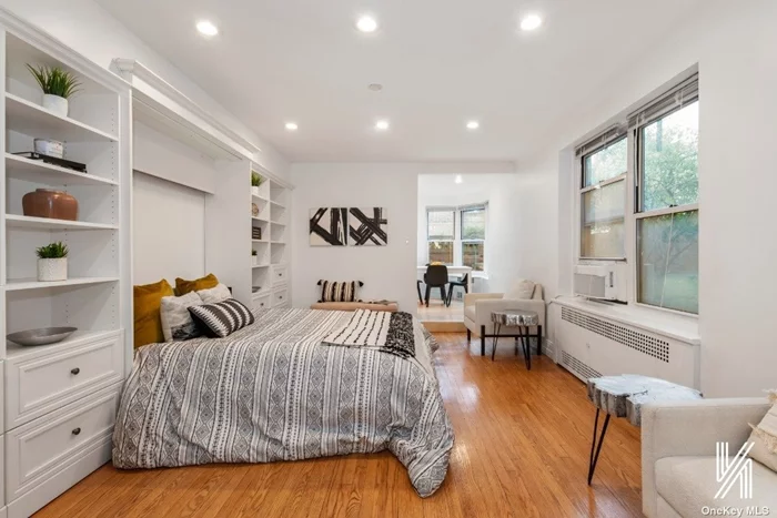 Located in the historic district of Jackson Heights, this pin-drop quiet studio in The Carlton House offers a serene atmosphere. Crisp white tones and gorgeous hardwood flooring cascade across the entrance that can serve as a seating area or office space. In the heart of the studio, there is a queen-sized Murphy bed with multiple built-in drawers and shelves on either side. The space is versatile and provides room for additional furniture, allowing you to personalize it to your liking. If you&rsquo;re looking for a peaceful retreat, this unit blocks out external noise, making it the perfect spot to read a book. The eat-in kitchen is a chef&rsquo;s dream, featuring modern shaker cabinetry, a portable dishwasher, and a dining area with three windows. Entertain guests or enjoy a cup of coffee with views of English garden homes. The bathroom features a glass-enclosed tub and modern fixtures. There is plenty of storage in the unit with two large closets. Living here means you have exclusive access to community perks such as a part-time doorman, gym, laundry room, garden, and garage. When you venture out, you can easily explore the many cafes, shops, restaurants, supermarkets, and schools. Its proximity to the train station allows for an easy commute to the rest of the city. The maintenance is $464.62 per month, and there are no subletting or dogs. The opportunity waits for you to create the New York apartment of your dreams!