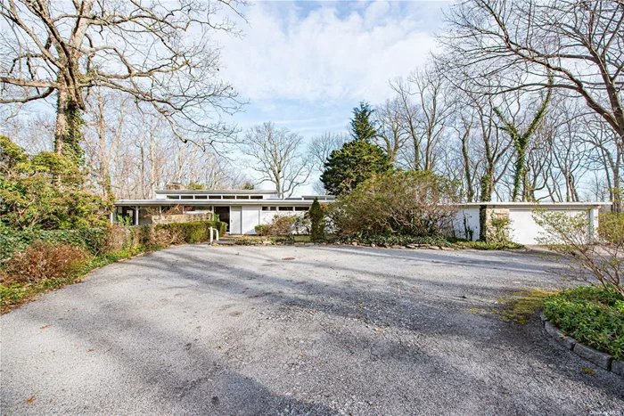 Discover the allure of this Frank Lloyd Wright inspired , mid-century modern in Laurel Hollow/Cold Spring Harbor schools, boasting captivating waterviews from all rear facing rooms. This 5 Bedroom/5 bathroom home offers the perfect blend of tranquility and modern elegance in over 2 acres of private wooded land . Walls of glass invite the natural beauty of the outdoors inside, creating a seamless connection with the lush surroundings . The interior features clean lines , high ceilings , and wood flooring creating a warm yet contemporary ambiance. The primary bedroom is a true retreat , complete with a fireplace , en-suite marble bathroom and waterviews. 3 of the bedrooms have en-suite bathrooms. The kitchen is equipped with newer appliances from Miele , Bosch and Electrolux . This property is enveloped by nature , offering unparalleled privacy and sense of escape as you enter a long private driveway . Its location offers privacy and convenience and a rare opportunity to experience contemporary luxury living in Laurel Hollow .