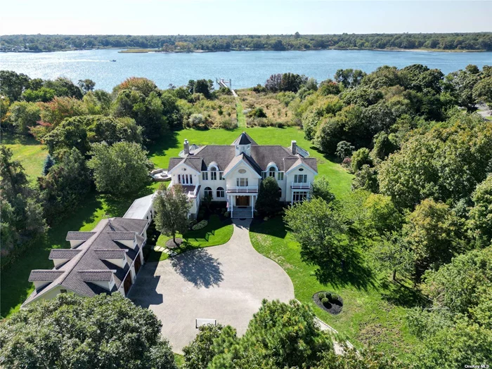 Escape to a serene 4.74 acre waterfront haven in Center Moriches. Tucked 600&rsquo; from the road, this private estate, built in 2003 seamlessly blends timeless elegance with modern convenience. Traverse the winding wooded drive to the main courtyard where a meticulously crafted over 7000 sqft home awaits. Stepping into the entry foyer you can see clear thru to the water. Look straight up 35 feet to the octagon cupola. The main floor, adorned with Douglas fir wood floors, features a family room with fireplace, an inviting octagon conservatory, and chef&rsquo;s dream kitchen boasting a double oven Wolf stove. French doors lead to bluestone patio enveloped by acres of private yard, complete with an outdoor cooking area and firepit. The upper-level hosts 4 bedrooms, including primary suite with fireplace, walk-in closets, and balcony with scenic views. Each bedroom is a retreat of its own, with ensuite baths, balconies, and decks. Over 200&rsquo; of Forge River waterfront with 40&rsquo;of floating dock and boat lift.