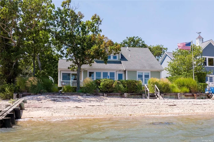 Nestled on the shores of Pipes Cove, this exquisite bayfront home offers the ultimate beach lifestyle with unparalleled relaxation and panoramic views from Conkling Point to Shelter Island. Perfect for both tranquil moments and exciting activities, you can enjoy the waterside patio on Wednesday evenings to watch the Shelter Island sailboat races and have front-row seats to the annual 4th of July fireworks display. Early risers will be captivated by breathtaking sunrises over the bay. Launch kayaks, paddle boards, or small sailboats from your private beachfront and explore the waters at your leisure. The home exudes warmth and character, inviting you to unwind and revel in the simple pleasures of life on the bay. The open floor plan with living, dining, and kitchen areas is thoughtfully designed to maximize water views and natural light. The primary suite is conveniently located on the first level, accompanied by two additional bedrooms and a full bathroom. Upstairs features a loft and unfinished space ready to be built out according to your needs. All of this is just a 3-minute drive to the coveted Greenport Village, offering dining, shopping, and entertainment options. Whether you seek a serene retreat or an active waterfront lifestyle, this bayfront home provides the best of both worlds.