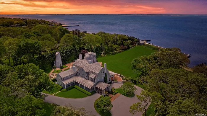 This majestic, one-of-a-kind estate is set on 4+ private, resort-like acres south of Montauk Highway. Its unique location on the southwest-facing waterfront provides incredible sunset views over Seatuck Cove and Moriches Bay from large windows throughout the bright, airy main residence. Perfect for entertaining, the meticulously updated 9-bedroom, 9.5-bath main home features a chef&rsquo;s kitchen with granite countertops, Wolf stove, dual ovens and dishwashers, and a 17-foot island. There&rsquo;s a living room with a built-in bar and wood-burning fireplace, a dining room, family room, handsome library and sunroom with wood-burning fireplaces, and a temperature-controlled wine cellar; and French doors lead to an ample patio overlooking the water. The primary bedroom has dual closets, custom built-ins, a bathroom with radiant floor and dual vanities, and a porch with sweeping water views. A former 19th century hunting lodge, the home blends old world charm with modern-day amenities, including an elevator and state-of-the-art mechanical systems, and features a porte cochere for shelter when getting in and out of vehicles. The sprawling property, which is bordered by tall perimeter trees and accessed through a gated entrance, includes a four-bedroom guest house with full kitchen; a detached five-car garage with commercial-grade hydraulic car lifts; a charming, refurbished, old-fashioned windmill; and a pool house with sauna, and gym overlooking the 45x20 heated saltwater gunite pool. A sweeping, lush lawn extends down to 234 feet of waterfront, where there are docks, a sandy beach and a boathouse. Har-tru tennis courts complete the country club experience. There&rsquo;s little reason to ever leave!