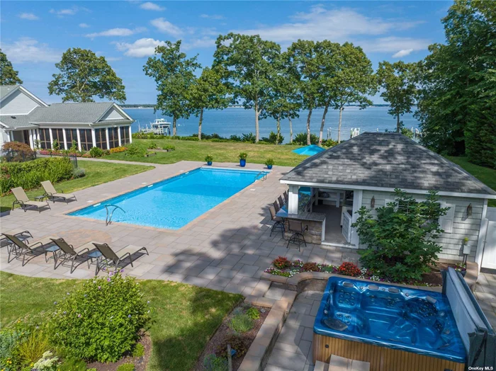 Paradise Point Road is one of the most prestigious addresses on the North Fork. This stunning home sits on 3.28 acres, has 252 ft of waterfront on the bay with its own sandy beach, newly built dock, and more! Privacy abounds with an electric entrance gate with telecom followed by a long tree lined driveway to this 5 bedroom, 6 bath home. All 5 bedrooms have ensuite baths, the primary bedroom overlooks the water with doors leading out to an expansive backyard. When you enter the home, the first thing you see is the bay! The foyer opens into a serene sitting room with floor to ceiling glass doors and panoramic water views. The great room includes an impressive stone fireplace which is easily controlled by remote for an instant gas flame. Also included in the great room is a new wet bar with ice maker, wine-fridge, sink and wine rack perfect for entertaining! The kitchen and dining areas both overlook the water with doors to the outdoor space and to a magnificent screened-in porch that has ample space for large gatherings. The outdoor space is an entertainer&rsquo;s paradise, with outdoor speakers, a spacious bluestone patio equipped for a large dining table, a heated saltwater pool with an automatic pool cover, separate hot tub, pool house with wet bar, outdoor shower, gas firepit and beach cabana/boat house equipped electric and water. Smart technology throughout the home. Generac generator with cellular monitoring device. This home has been fully upgraded over the last 10 years including electric, insulation, etc. Too many upgrades to list. Must be seen in person to truly appreciate!