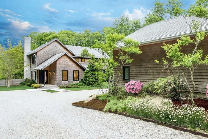Located in Bridgehampton, and just 2.5+\- miles to the Village of Sag Harbor, this open, airy retreat features 5 bedrooms with 5 full and 2 half baths across 5, 000+\- sf. The sophisticated modern farmhouse has been expertly crafted and is sited on an impressive 4+\- acre setting that affords complete privacy and tranquility. Large expanses of glass and elegant terraces throughout foster stunning views of forest and field. An open floor plan provides a large living room with fireplace, formal dining area, and professional chefs kitchen with a center island workspace and casual counter dining for 4. On the second level, a primary en suite with fireplace and terrace also includes a soaking tub, double sinks and walk-in closet. Two additional en suite guest rooms as well as a dedicated laundry room are offered. The lower level includes a guest bedroom, powder room, and a sauna with additional unfinished storage space and a mechanical room. A heated gunite pool is bordered by a bi-level stone patio with a pergola. Additional amenities include a free-standing 2 car garage with studio space and full bath.