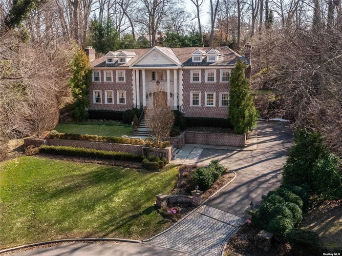 Step into this impressive and stately brick 6 bedroom colonial in the sought-after Village of Flower Hill and you will immediately appreciate the finest craftsmanship and elegant finishes throughout its over 7100 square feet of luxury living. With grand formal rooms perfect for entertaining, and casual spaces to cozy up by the fire, play a game of pool, host a movie night, work, exercise and relax, this fine residence offers a retreat for the entire family. Special highlights include a classic eat-in kitchen with a large center island, food pantry, laundry room, a family room with fireplace and french doors leading to rear patio, a custom billiard room with fireplace and bar/butler&rsquo;s pantry, ideal for entertaining. The finished lower level boasts high ceilings with an oversized recreation room, home cinema, guest suite, second laundry room and 3 car garage. The second floor features a serene primary suite, 2 additional large bedrooms, each with a new en-suite bathroom, and an additional 2 bedrooms that share a spacious bathroom. With a home generator, central vacuum and abundant storage, every important amenity has been carefully considered. Set on an acre of landscaped property with outdoor kitchen, mature plantings and complete privacy on a cul de sac, yet minutes from train, town and schools. Munsey Park Elementary School. Taxes are being grieved.