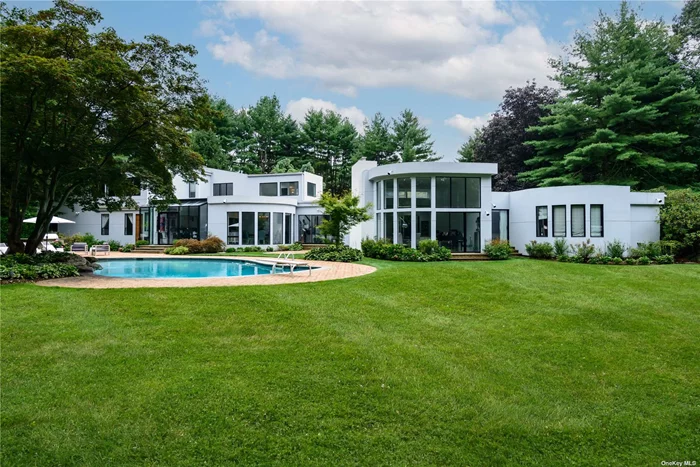 A spectacular, stunning, designer-owned Contemporary gated home nestled on sprawling, two flat acres on a quiet cul-de-sac in the sought after village of Old Westbury. This magnificent approximately 10, 000 sq ft home boasts seven generously sized bedrooms, each with its own en-suite bathroom. The house exudes modern elegance, with floor-to-ceiling windows, vaulted cathedral ceilings, with an abundance of natural light and panoramic views. The backyard oasis showcases a resort-style sparkling heated gunite pool, tennis/pickleball court, basketball court, playground, and an oversized patio with built-in outdoor kitchen, perfect for entertaining. On the main floor you enter through a dramatic foyer, looking over a spacious elegant dining area, luxurious living room, with beautiful fireplace and wet bar, a warm and inviting den, exquisite powder room, The heart of the home is a large gourmet kitchen with state-of-the-art appliances, plenty of counter space, and a breakfast area that invites the outside beauty in. The luxurious primary suite is a sanctuary of sophistication, offering a private retreat, with a spa-like ensuite bath and sauna, dressing area, sitting area, office and ample closet space. Step up to the upper level with a dramatic staircase to an additional 4 generously sized en suite bedrooms and a recently added guest suite containing a bedroom, bathroom, kitchen, and living room, and balcony. The lower level is the perfect place for recreational activities, it&rsquo;s a sportsmen&rsquo;s paradise and includes an indoor racquet ball/wally ball/ basketball court, home gym, full bath, play area, art closet, ping pong, laundry room, bedroom, office and storage. Other amenities include a 2-car garage, maids&rsquo; room with full bath, security system, mudroom and a sports court viewing area. Everything at your fingertips including easy access to the city and the Hamptons, low taxes. Near shopping, dining, golf/country clubs, and much more!