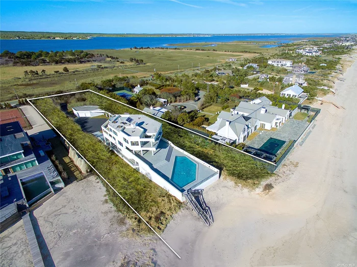 Dune Road Oceanfront in Quogue: Set back from the road, this quality-built, custom home sits high on a dune in coveted Quogue, with 107 feet of ocean frontage. It offers 10, 000 square feet of living space over three levels, with unobstructed views of the ocean and bay from within the house & on multiple decks, as well as a large, waterside pool. Giant windows throughout the building provide vistas of nature and beautiful light. Gracious entertaining spaces include the double-height living room with fireplace, dining room, playroom, and media room. The primary suite occupies its own level, complete with two private decks, two bathrooms, and a large loft used as an office. Seven other bedrooms, and seven and a half baths, are dispersed over the other two levels. Come and see how your oceanfront life could be!