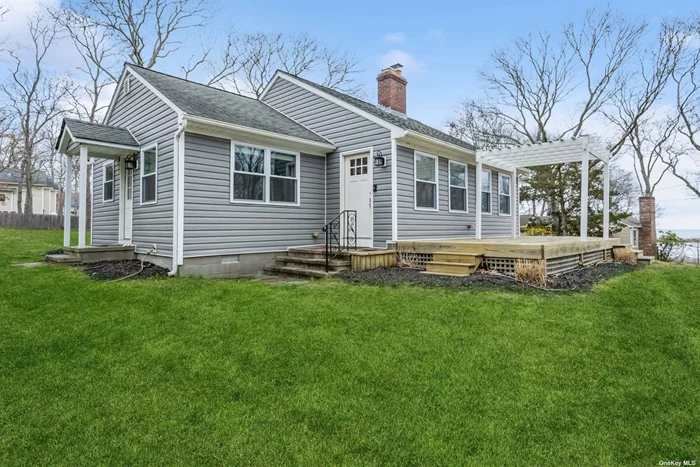 This recently renovated beach cottage is ready for you to move right in and enjoy the winter water views of Squires Pond and the Great Peconic Bay, as well as all that summer in the Hamptons has to offer with the beach only just a short stroll away! The ranch style living makes life easy as soon as you step into the entry foyer with its built-in hall tree cubby, and then move through to the open great room with cathedral ceilings, a cozy fireplace and the large eat-in white kitchen with granite counters, stainless appliances (including a gas stove), center island and subway tile backsplash. There is also a separate room that could be used as an additional den or office with sliding doors out to a large deck with pergola and more water views. The two bedrooms consist of one with an ensuite bath and a walk-in closet, as well as a second large sunny bedroom with water views and two closets. There is a separate guest bath and a laundry room with stackable appliances. The house fills with lots of natural light in addition to the LED high hats that are found throughout. This one is not to be missed!