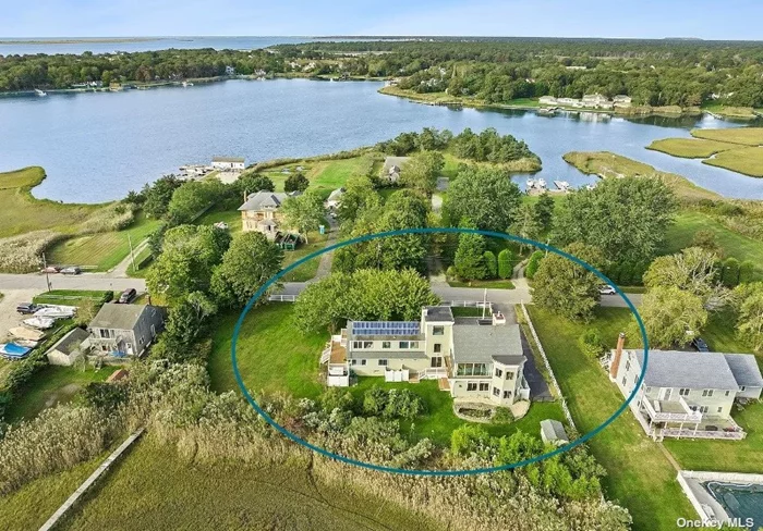 Impeccably renovated from top to bottom, this stylish five-bedroom contemporary is located on the water in East Moriches with a private dock. No expense was spared on this gorgeous light-filled 4400 square foot home, which boasts two fireplaces, a massive open kitchen with 40 square foot quartz island and expansive 180-degree water views. The open plan provides for sizable and distinct living and dining areas. The kitchen is a chef&rsquo;s delight with stainless steel appliances including a 6-burner gas range, slide in hood, and oversized sink. Custom shaker cabinetry is topped with quartz counters offering plenty of room to entertain. In addition to the wide-open layout in the Kitchen/Living Room/Dining area, this sun-drenched home features a separate family room and office-loft as well as a two-car attached garage and driveway that fits six cars. The large, wrap-around side and backyards feature an irrigation system, new landscaping, and leads to private dock with access to Moriches Bay. In addition, don&rsquo;t miss the gorgeous botanical Japanese cherry collection in the front yard. This home is equipped with central HVAC, solar power, a finished basement, walk-in closets and walk-in laundry room. Pool permit in progress.