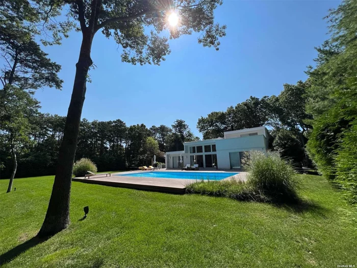 Newly renovated 2, 880 sq.ft. modern home tucked away on 1.31 acres in East Quogue. Designed for a spa atmosphere, outdoor landscape features a heated 20 x 40 swimming pool with new liner and stadium steps, outdoor dining table, Weber grill, patio umbrellas, lounge chairs, and outdoor shower. There is a firepit-perfect for enjoying summer evenings. All rooms and bathrooms have been newly renovated and the wood floors have been updated with refinished red oak. The kitchen counters are Italian Calacatta marble as are all bathroom vanities. The primary bedroom on the second floor has king size bed, a walk-in closet, a bathtub and an open shower and its own private deck. There are four bedrooms on the first floor-all with queen beds. An en-suite bedroom has a walk-in closet, a bathroom with tub and shower and access to the deck and pool. Two guest bedrooms share a bathroom. There is TV room/additional bedroom with a pullout sofa, bathroom and a private deck. Close to ocean and bay beaches