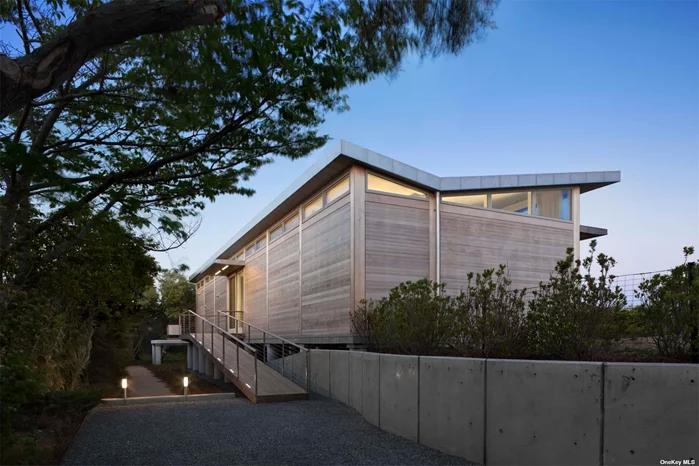 Nestled only a simply moment from the Atlantic Ocean, amidst the serene Amagansett Dunes, stands a Modern Beach Cottage that is the epitome of coastal elegance and contemporary luxury. Crafted by the renowned architect Francois de Menil, whose design prowess has garnered accolades, this home is a testament to turnkey perfection. It offers a rare chance to inhabit the dunes with unparalleled style, comfort, and luxury. In addition to everything that makes this property so special, it has now been granted approval for a swimming pool. This feat took the current owners nearly two years and means that after purchasing the property the new owners will have an option to install an 8&rsquo; by 30&rsquo; gunite saltwater pool. In a locale where such approvals are notoriously difficult to secure, this pre-approved amenity is a significant boon, potentially sparing years of bureaucratic navigation for the new owner. Drawing inspiration from its coastal environs and flanked by protected lands on three sides, this refined abode is a harmonious blend with nature, fostering an effortless flow between its indoor and outdoor havens. Constructed with integrity, utilizing reinforced steel, high-density concrete, and Alaskan yellow cedar for its cladding, the home is a fortress of sustainability and comfort. Stainless steel fixtures and eco-friendly materials further enhance its durability and environmental consciousness. The interior of the residence is a celebration of open space and light, featuring a grand room that encompasses a living and dining area, crowned by a chef&rsquo;s kitchen that was meticulously rebuilt in 2023. Expansive 14&rsquo; south-facing Duratherm sliding doors invite the southern sun, while three cozy bedrooms, two full baths, and a sun-drenched enclosed sunroom complete the intimate quarters. Outside, the property boasts a custom outdoor shower and a sprawling sun deck-both perfect for social gatherings or tranquil solitude in the sea air. The home&rsquo;s luxuries extend to polished Portland cement floors with radiant heating, elegant honed marble vanities, a deep soaking tub, and discreet pocket doors. The bespoke beechwood cabinetry, automated Lutron shades, and floor-to-ceiling natural fiber draperies add a touch of sophistication. Modern conveniences are not overlooked, with a stainless-steel Miele washer and dryer, an eco-friendly coconut fiber water filtration system, a comprehensive alarm system, and a robust 48 KW natural gas generator ensuring uninterrupted comfort. This Modern Beach Cottage is more than a home; it&rsquo;s a sensory experience. The gentle ocean breezes, the rhythmic lull of the waves, and the legendary Hamptons luminance that has stirred the souls of artists for ages-all these elements are seamlessly woven into the fabric of this Amagansett Dunes jewel, making it a living masterpiece that awaits its next discerning steward.