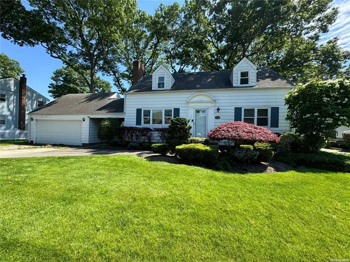 Charming Cape Cod home featuring a cozy living room with a fireplace, 5 spacious bedrooms, and 2 full bathrooms. Enjoy the expansive basement and a 2-car garage. The property boasts a beautiful, serene yard. Conveniently located close to town, restaurants, shops, and the LIRR.