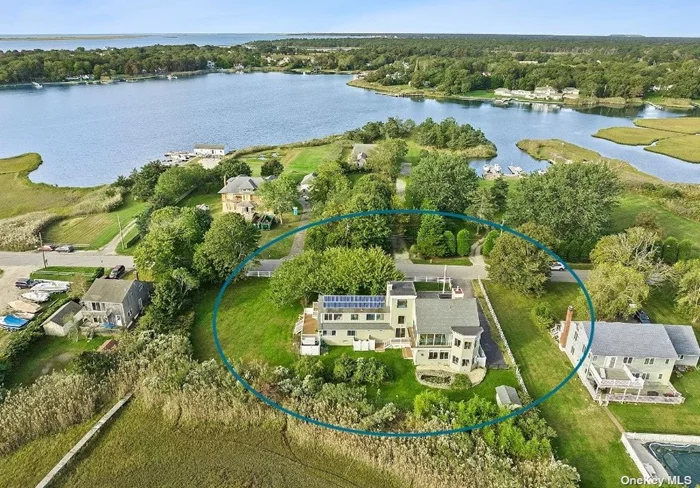 Impeccably renovated from top to bottom, this stylish four-bedroom contemporary is located on the water in East Moriches with a private dock. No expense was spared on this gorgeous light-filled 4400 square foot home, which boasts two fireplaces, a massive open kitchen with 40 square foot quartz island and expansive 180-degree water views. The open plan provides for sizable and distinct living and dining areas. The kitchen is a chef&rsquo;s delight with stainless steel appliances including a 6-burner gas range, slide in hood, and oversized sink. Custom shaker cabinetry is topped with quartz counters offering plenty of room to entertain. In addition to the wide-open layout in the Kitchen/Living Room/Dining area, this sun-drenched home features a separate family room and office-loft as well as a two-car attached garage and driveway that fits six cars. The large, wrap-around side and backyards feature an irrigation system, new landscaping, and leads to private dock with access to Moriches Bay. In addition, don&rsquo;t miss the gorgeous botanical Japanese cherry collection in the front yard. This home is equipped with central HVAC, solar power, a finished basement, walk-in closets and walk-in laundry room.