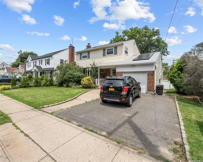 Bright and welcoming home set on a lovely block in the heart of Malverne with Malverne Schools. First floor features an open layout with entryway, large living room, formal dining room, enormous custom kitchen with wood cabinets and granite countertops. There is a sunroom with French sliding doors leading to the backyard - perfect for get togethers.  A renovated half bath and bedroom complete the first floor. Upstairs you will discover another full, completely renovated bathroom with double vanity. The main bedroom is large enough for a king sized bed with plenty of space left over. A walk-in closet completes the main bedroom. Two additional big bedrooms complete the 2nd floor. A full basement with common space, utilities and bathroom. Hardwood floors throughout. Central air conditioning. Windows have been replaced. The garage has a high ceiling with automatic door opener. Double driveway is wide enough for 4 cars. Very near to restaurants, shopping, LIRR and so much more! One half block from town yet a WORLD away! This is a place you will love to call home!