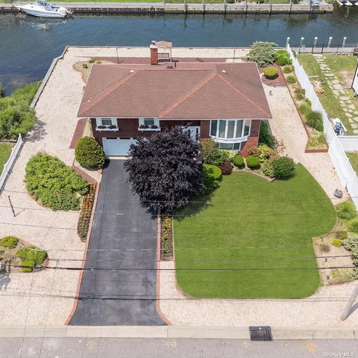 Discover the allure of waterfront living in the prestigious Sequams Colony development of West Islip, NY. This beautifully maintained High Ranch home is perfectly positioned on a canal with 90 feet of bulkhead, offering views of the Great South Bay. As you enter, a spacious foyer welcomes you and leads to the first floor, featuring a full bathroom, walk-in closet, a generous family room/potential 4th bedroom, and a recreation room with a wet bar. This floor also provides access to the two-car garage, which boasts a separate entrance from the outside.  Upstairs, the second floor offers a bright and airy primary bedroom with direct access to a full bathroom, two additional bedrooms, an inviting eat-in kitchen, and a dining room that opens to an outdoor deck with bay views. The dining room flows seamlessly into the living room, creating an open and welcoming space. Beneath the areas currently carpeted, you&rsquo;ll find original hardwood flooring, adding to the home&rsquo;s inherent charm. This impeccably maintained home is ready for your personal touches and offers a perfect blend of tranquility and convenience. Located close to the Babylon Yacht Club, Good Samaritan Hospital, and the Robert Moses Parkway, easy access to Fire Island. Additionally, the vibrant Babylon Village, renowned for its exceptional dining and retail options, is just a short distance away. Enjoy the best of waterfront living in this vibrant and sought-after community.