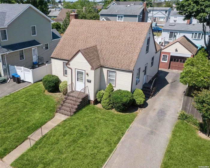 Cozy Expanded Cape is situated in Mandalay section of Wantagh. This nicely maintained home boasts 2 bedrooms on the main level adjacent to a full bath and brightly lit living room. The 2nd level contains one substantially large bedroom with a walk in closet that invites a multitude of spatial ideas. The kitchen has a dining area with ample windows overlooking the manicured yard along with a side entrance to the driveway for convenience. The side entrance also leads to the huge basement with recreational space, workshop, and where the utilities can be found. Hardwood floors can be uncovered throughout the main level, underneath wall to wall carpeting. Finally, the private driveway guides you to the oversized detached 1 car garage. Short distance to Merrick Rd and Wantagh Park & Marina. Features: Newer Roof & Siding,  Gas Heat w/Sep Hw Heater, New Paved Street