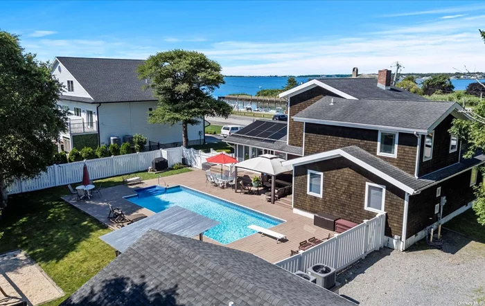 Location! Location! The Pine Neck Landing Community in East Quogue!!! Enjoy the community&rsquo;s boat dock across the street!!!  Experience the ultimate waterfront lifestyle just three houses from Shinnecock Bay. This beautiful cedar shake home has a stunning residence, a community dock with easy access to open water, and a man-made beach on the bay. Wake up to big water views from almost every room in this lovely 4-bedroom, 3-bath home. Enjoy indoor and outdoor living with walls of windows flooding the home with natural light and Ipe decking wrapping around the front and side of the house, perfect for sitting, dining, lounging, and soaking in the views. The inground heated pool provides an oasis for relaxation and entertainment. The open floor plan creates an inviting atmosphere for gatherings, flowing seamlessly from the living areas to the backyard through double sets of sliding glass doors. The kitchen, den, and dining room feature cathedral beamed ceilings with bead board accents. The kitchen boasts an island, granite counters, a glass tile backsplash, and ample cabinetry. Enjoy cozy meals by the full-wall stone fireplace in the dining room, with a bluestone-topped raised hearth and a bow window framing picturesque views. The main level includes a large bedroom with a walk-in closet and a full bath, with plumbing ready for a second full bath. Upstairs, find two additional bedrooms, a full bath, and the expansive primary suite on the third level. The primary suite offers a luxurious retreat with a full bath, a walk-in closet, and breathtaking water views. The fenced property is designed for a vibrant lifestyle, featuring a spacious play area, a cabana/garage, storage, and a large deck surrounding the inground pool. This home is perfect for water lovers, offering endless opportunities for swimming, boating, and enjoying the serene bayfront setting. With its proximity to Shinnecock Bay, this home combines luxurious living with the beauty of nature, creating an unparalleled waterfront experience. Whether you&rsquo;re lounging by the pool, hosting a barbecue, or taking a short 2 minutes to get to the bay, this home gives a lifestyle of relaxation and enjoyment.