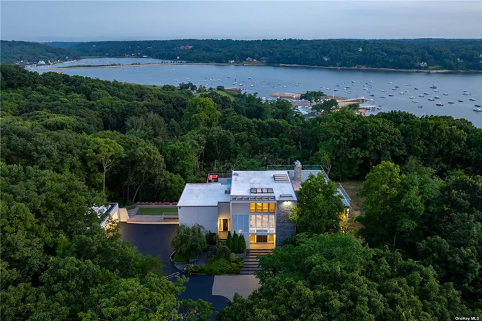 Water Views! Discover Modern water view coastal living. This expansive home is situated on 2.7 private acres in the Village of Lloyd harbor. Experience the essence of modern with walls of glass capturing the natural lighting and scenic views of Cold Spring Harbor. Beyond the views enjoy a sunset from the transformed roof top. This open floor plan creates a sense of flow and seamlessly connects the indoor and outdoor space. Welcome to the primary suite - a sanctuary of luxury and comfort within this modern home. Designed with meticulous attention to detail, the primary suite offers a retreat-like experience, seamlessly blending functionality with exquisite aesthetics. As you step into the spacious bedroom, natural light floods through expansive windows, illuminating the carefully curated d?cor offering two separate bathrooms, walk-in closets and a wood burning fireplace. There is a main floor spacious bedroom with a sliding door to a private deck overlooking the pool area. The additional 3 bedrooms offer en suite baths and ample closet space, all with neutral pallets of color. This unique residence has been transformed with new windows and all new flooring and custom wall applications blending the aesthetic appeal but also harmonize with the natural environment outside. A perfect setting for those seeking a peaceful retreat, extraordinary updates, and additions. The open concept is ideal for relaxing, entertaining or simply enjoying the scenic surroundings to include the sun drenched in ground saltwater pool. A 7-car garage with additional lifts to accommodate 11 cars. In addition, this home enjoys Cold Spring Harbor and Lloyd Harbor beaches along with private police. Cold Spring Harbor School District #2.