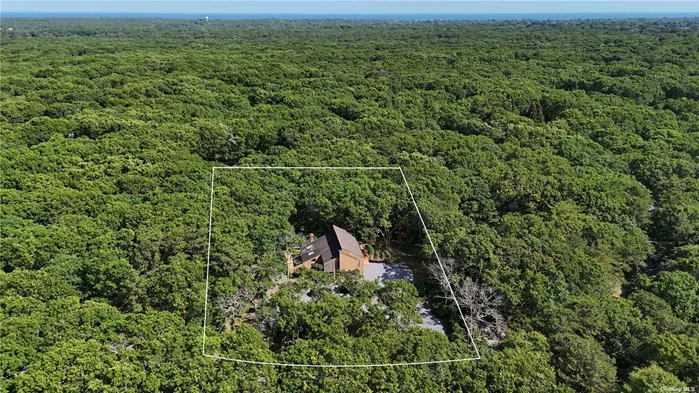 This exquisite 2-story home is situated on the quiet and sought-after Karin Drive in East Hampton Oaks, featuring a circular driveway that enhances its elegant curb appeal. Surrounded by approximately three acres of protected land, this property offers unparalleled privacy and seclusion, with a serene backdrop against lush nature reserves. The residence exudes tranquility and is characterized by its serene ambiance. In close proximity, residents and their guests have exclusive access to two tennis courts within the neighborhood, providing ample recreation opportunities. Main Floor: Upon entry, you are greeted by a sunny living room with a cathedral ceiling, skylights, and a fireplace. This space seamlessly connects to an extensive outdoor deck, perfect for entertaining. The separate dining room also has sliding doors that open to the deck, creating a harmonious indoor-outdoor flow. The eat-in kitchen is well-appointed and conveniently adjacent to a mudroom and laundry room, which feature a separate entrance. A guest closet and a large powder room add to the convenience of the main floor. The expansive 1, 400 sq. ft. deck wraps around three sides of the house, offering breathtaking views of the protected undeveloped land. The main floor also includes an attached two-car garage with plenty of storage space. The first floor boasts four bedrooms and two full baths. The principal bedroom features a cathedral ceiling, an ensuite bathroom, and a private balcony, providing a perfect retreat. All the other bedrooms offer picturesque views of the beautiful trees and dense vegetation of the protected open area. Additionally, the home includes a full basement with high ceilings, offering potential for various uses. As you enter from the garage, you are greeted by a spacious and functional mudroom designed to keep your home organized and clean. This versatile space features a washer and dryer. Property Details: - Lot Size: 31, 589 sq. ft. - Interior Square Footage: Approximately 2, 150 sq. ft. - Real Estate Taxes: $5, 990 annually - Built-in 1980 - Yearly Association Fee: $225 (covers insurance and maintenance of the green belt and tennis courts) - Maintenance Fee: $225 for 61 houses -Attached Garage 525 sq. ft. This East Hampton retreat, set on nearly an acre of land, offers the perfect blend of comfort, privacy, and natural beauty. It is an ideal home for those seeking a serene lifestyle in a prestigious neighborhood.