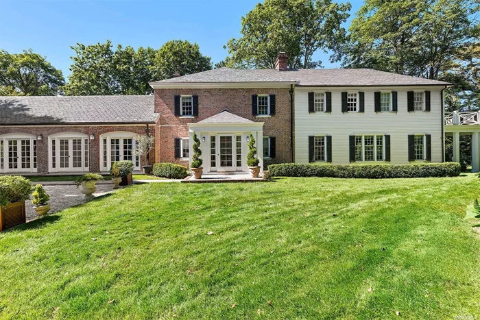 Offering 5 bedrooms and 5.5 baths on a full acre with a private dock on Hayground Cove in the Water Mill estate section, this exquisite slate roof Georgian carriage house built circa 1920 has been extensively renovated with every modern convenience. It features an open floor plan flooded with light from sets of French doors with interiors finished in a casually elegant d?cor. On the first floor, a welcoming foyer offers views of the circular dining area, which is bookended by a large formal living room (31&rsquo;6 x 19&rsquo;9) with a fireplace on one side and a kitchen/dining/common room with 10&rsquo;11 ceilings on the other. An en suite bedroom, additional full bath, laundry room, and den with patio leading to the heated gunite pool are also provided. The second floor features a primary en suite with double closets, a private balcony, and three additional guest bedrooms, one of which is en suite. Grounds are meticulously manicured and include a private path to the dock, which provides access to Mecox Bay for boating and water sport. Additional amenities include a boat and golf cart. The idyllic location is moments to Water Mill village and also near renowned W. Scott Cameron and Sagg Main Beaches and the villages of Bridgehampton and Southampton.