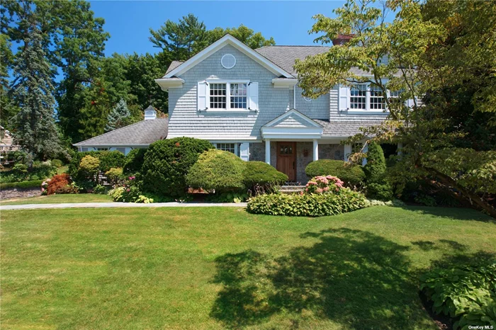 This Beautifully Designed Classic Cedar Shingle & Stone Hampton Style Colonial Is Set Back On .80 Acre Of Lush Property In The Sought After Village Of Plandome Manor. This 6/7 Bedroom Home Was Completely Renovated & Expanded In 2005 With A Well thought out & brilliantly Designed Floor plan Allowing For Spacious Entertaining Spaces to enjoy a relaxed & casual Living Style With Your Family & Friends . Step into this custom built home with a lovely formal dining room , an oversized living room with built ins & a charming feature wall which surrounds the fireplace , wide plank oak flooring which provides a cozy & relaxing setting . A gourmet kitchen with island, Coffered Ceiling detail , High end appliances including a 48inch Wolf range, Subzero Refrigerator , 2 dishwashers, walk in pantry & beautiful stone countertops set the tone for this charming space which will be the heart of this very special home. A sun filled breakfast room & spacious family room with stone fireplace & beamed ceiling will be a family favorite . A first floor private primary suite was thoughtfully designed with an ensuite bath. Two additional first floor suites provide endless possibilities as a separate family bedroom/den or work from home office space . The second level offers an open den area , three spacious family size bedrooms, one full bath & a true primary suite oasis with two walk in closets, a lovely marble primary bath with cathedral ceiling & skylights, spa tub . Step outside to enjoy fall dinner parties & entertaining under the stars on the expansive bluestone patio .Few properties offer the opportunity & potential for an  in ground pool or tennis/sports court. Or simply enjoy the breathtaking park like property with its mature landscape & gardens. Beautiful seasonal waterviews is an added bonus . Close to the Plandome train station with parking at Plandome Manor lot for an easy commute . Enjoy the finest in dining & shopping at The Americana, one of the many gems of Manhasset .