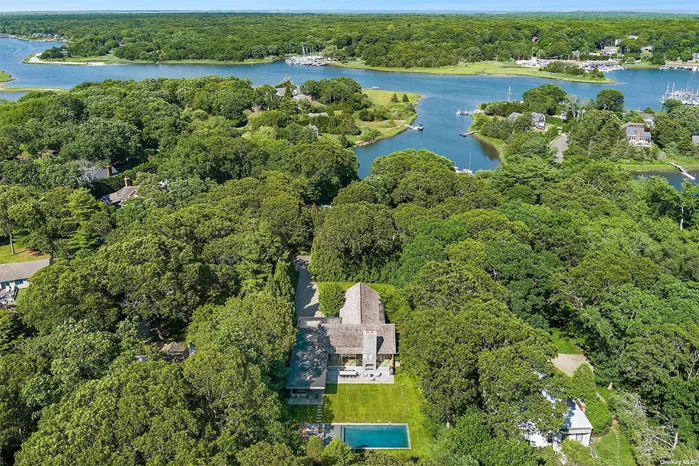 This custom home epitomizes the essence of true indoor/outdoor living within the expansive single-level layout, complemented by a finished lower level. Featuring four bedrooms, four and a half baths and a separate den with an inviting outdoor seating area. The bright and airy great room seamlessly integrates the kitchen, living, and dining area which opens to the outdoors through a wall of accordion Arcadia sliding glass doors and screens. The kitchen is equipped with top-of-the-line Miele appliances including a 5-burner induction stove, two ovens, dishwasher, refrigerator and freezer. Stunning Carrara waterfall countertops, island with seating and adjacent to the kitchen, the butler&rsquo;s pantry complete with a sink, ice maker, and a wine fridge. The primary bedroom is a sanctuary of comfort, boasting vaulted ceilings and walk in closet. The primary bath is equally luxurious, featuring a shower with a rain head and a deep soaking tub. Two additional bedrooms, connected by a bath, complete the first floor. The lower level is designed for relaxation and entertainment, with polished concrete radiant flooring, a wet bar, a media area, and an additional bedroom with an en suite bath. The home is equipped with a Sonos sound system throughout, windows with custom shades, and modern conveniences which can all be controlled via smart phone. Additional amenities include a one-car garage, a spacious first-floor laundry room with sink and built in&rsquo;s, water filtration system, geothermal heating, an outdoor shower and a generac generator. Outside, the large bluestone patio is perfect for gatherings, featuring an outdoor fireplace and a covered seating area. The 18 x 40 saltwater gunite pool, complete with a sun ledge and an attached deck with lounge chairs, offers a serene escape. Just three miles to the Village center, and less than one and a half miles to Three Mile Harbor marinas and Round Swamp Farm. Residents within Hampton Waters association, enjoy access to a beautiful private beach and dock.