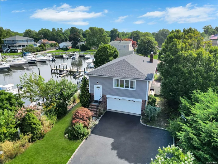 Discover the epitome of waterfront living in this newly remodeled hi-ranch located in the coveted Babylon Beach Estate. This exquisite home boasts an open-concept design with stunning hardwood floors throughout, offering both comfort and luxury. Interior Features: - **4 spacious bedrooms** - **2 elegantly tiled bathrooms** - **Beautiful gas fireplace** - **Gourmet kitchen** with brand-new stainless steel appliances and quartz countertops - **Versatile room** ideal for a home office or guest suite - **Cozy den** for relaxation - **Chic bar** perfect for entertaining - **Generator transfer switch** for added convenience Step outside to a meticulously crafted stone patio leading to your private dock, complete with 50 feet of bulkhead, allowing you to fully enjoy the waterfront lifestyle. Nestled in a serene coastal setting, this home provides exclusive access to a private bay-front beach, proximity to Good Samaritan Hospital, and easy access to Robert Moses Parkway. Enjoy effortless boat trips to Fire Island right from your backyard. Located just minutes away from major highways, parks, and schools, this home is part of a very tight-knit community. With flood insurance costing less than $130 monthly, this dream home offers a perfect blend of modern living and a tranquil coastal lifestyle. Embrace the charm of bay-side living in this exceptional property.