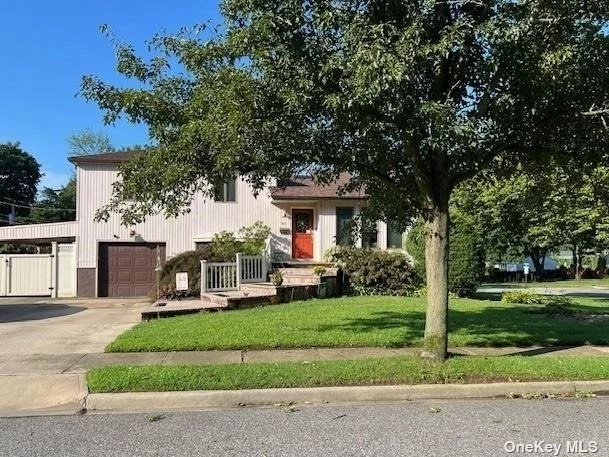 This split level home offers a blend of style and functionality. This sun filled home has been freshly painted and features cathedral ceilings in the living room with 2 skylights. Hardwood floors adorn the living space in the living and dining room. The kitchen was extended and features cathedral ceilings with skylights, SS appliances along with a Butlers Pantry where you also have access to your rear yard and patio. There are 3 generous size bedrooms along with a newly designed Spa Bathroom featuring a whirlpool,  separate shower, large vanity, toilet and bidet. The primary bedroom comfortably fits a king size bed and also features a mirrored wall of closets. A family room on the first floor offers an entrance into your garage. There is also a full bathroom, laundry area , sink, 2nd refrigerator and access to the rear yard. The basement is finished with 2 rooms and a Cedar Closet. You can create the space to suit your lifestyle needs. The rear yard is very spacious and completely fenced for your privacy, it includes a paver patio with an additional concrete seating area. The carport on the side is currently being used for a car but it can be used as a covered patio. The choice is yours. The added amenities include150 AMP electric service, Central AC, Sprinklers and a 4 car driveway for convenient parking. A Must See.