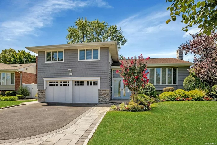 Welcome to this beautiful and bright 4 bedroom Split-level home in the coveted Woodbury Hills section of Plainview! The exterior of this home features brand new siding with stacked stone, new 2 tier trex deck, new paver walkway, custom landscaping, and a stacked stone chimney. The interior of the home features 4 bedrooms, 2.5 bathrooms, redone kitchen with vaulted ceiling and skylights, high end appliances, gas cooking range, electric double wall oven, walk in pantry, sliding doors to the deck from the kitchen as well as the lower level, oversized dining room, formal living room with vaulted ceilings, 2 car garage, laundry room on the main level, finished lower level, in ground sprinklers, hardwood floors, CAC, and 2 zone heat. This home is zoned for the Plainview-Old Bethpage school district.