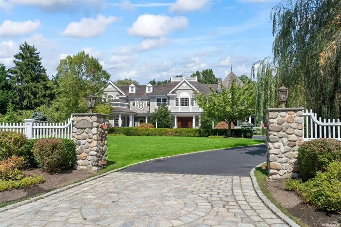 Introducing this exquisite Hamptons shingle-style Colonial in the highly sought-after Cold Spring Harbor Wawapek area, set on a sprawling 2-acre lot. This stunning property boasts commercial-grade construction with a durable steel infrastructure, ensuring unparalleled stability and longevity. The property features Brazilian Cherry hardwood floors and custom cabinet grade millwork throughout. As you approach the solid mahogany front doors, you will be greeted by the beautiful custom-made Pennsylvania-stained glass windows that flank them, creating a warm and inviting entrance. Upon entering the 22&rsquo; two-story foyer, you will be struck by the high ceilings that add to the grandeur of the space. The domed medallion chandelier, suspended from an electric hoist, is an impressive centerpiece that illuminates the entire area with an inviting glow. The true gem of this home is the impressive Great Room, which features soaring 30-foot-high ceilings adorned with custom-made Red Oak Vermont Timber trusses, providing an unforgettable sense of grandeur. The space is further enhanced by locally sourced Long Island River Rock, which surrounds the wood-burning fireplace and adds to the ambiance of the room. Additionally, the great room features wide plank rustic flooring, which perfectly complements the architectural feat and aesthetic of the space. The copper wet bar, complete with a two-zone pressurized wine server, provides the perfect gathering spot, making it the ultimate entertainment space. The magnificent kitchen, featuring eye-catching hand-painted backsplash tiles and custom cabinets, crafted by highly acclaimed Master Concepts, provides ample storage and adds an elegant touch to the space. The kitchen is equipped with top-of-the-line appliances, including a DCS 48-inch range with a grill and skillet and another in-wall convection oven, perfect for cooking up a storm for large gatherings or intimate dinners. Three Sub-Zero refrigerators/freezers offer plenty of space for storing groceries, while Miele and Fischer Paykel dishwashers makes cleaning up a breeze. Adjacent to the kitchen is a butler&rsquo;s pantry, which includes a built-in Miele coffeemaker and cup warming drawer for the early morning coffee or tea. The sunlit, circular breakfast room provides a cozy and inviting atmosphere, perfect for starting the day off on the right foot. Overall, this kitchen is the epitome of luxury and functionality, sure to impress even the most discerning of buyers. The main floor is completed with a mahogany wood coffered ceiling dining room, bedroom with en-suite, powder room, spacious mudroom, living room with fireplace with an adjacent sun-drenched music room, and a 4-car garage boasting Flow Wall cabinetry and slotted walls for future customization, mahogany doors and radiant heated epoxy finished floors. Stepping into the Primary Suite&rsquo;s reception foyer, the view is immediately drawn to the sunroom wrapped with windows and the beautiful wraparound bluestone balcony. The Primary Suite is finished with a gas fireplace, 2 spacious walk-in closets, and an en-suite bathroom with a steam shower and jacuzzi, sunlit from the 16-foot barrel dormer. The second floor also showcases a stained mahogany wood-paneled library suite complete with coffered ceilings, an adjacent fitness room and a spa bathroom with a sauna/steam room. The second floor is completed with a state-of-the-art laundry center, 2 en-suite bedrooms and 2 additional bedrooms with a connecting bathroom. These additional bedrooms feature cathedral ceilings. The lower level partially finished basement comes with an architecturally designed floor plan. Opportunity to finish this floor to your exact dream specifications. Options abound with spa, sauna, steam shower, fitness center, bar, wine cellar, playroom, storage center, powder room, media room, or golf simulator! The lower level contains 11-14&rsquo; high ceilings, radiant heated epoxy flooring, and a GarageTek-finished utility/mechanical room. With its unbeatable location, expert craftsmanship, and luxurious finishes, this Cold Spring Harbor property is a true masterpiece that will impress even the most discerning of buyers. It exudes elegance, sophistication, expert craftsmanship, and luxury, making it the perfect place to welcome guests and create lasting memories. CSH SD #2 and deeded mooring and beach rights at Eagle Dock.