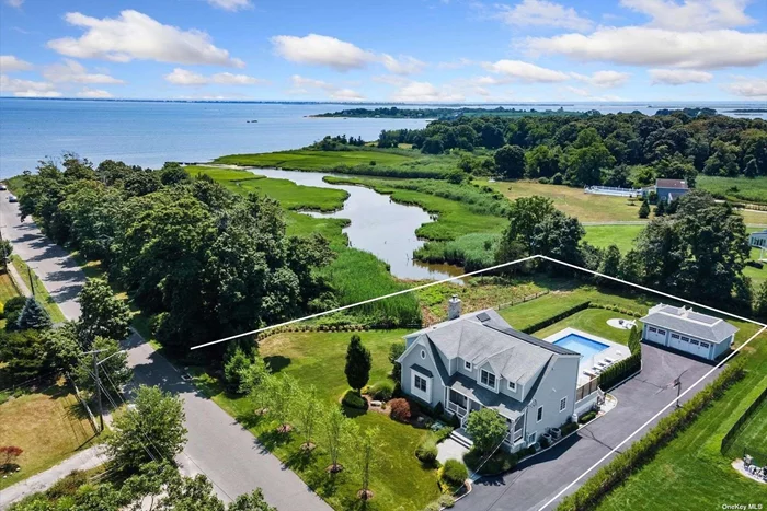 Welcome to a pristine retreat on the edge of The Hamptons, where serenity meets sophistication in East Moriches. This custom 4, 674 sq.ft. home is nestled on 1.09 waterfront acres, providing direct access for launching your paddleboard or a kayak. It adjoins protected wetlands, offering mesmerizing sunrise and sunset water views, with Dune Road on the horizon. Step inside to discover a bright and open floor plan, accentuated by 12-foot coffered ceilings and 6-inch wide plank oak radiant heated floors that flow throughout the main level. Expansive windows and sliders frame the breathtaking water views, seamlessly blending indoor and outdoor living. The beautiful chef&rsquo;s kitchen is complemented by a spacious dining area ideal for entertaining. This level also features a versatile home office, a cozy en suite guest bedroom, a convenient laundry room, and crisp half bath. Upstairs, the primary suite is a private haven boasting spectacular bay views and a serene balcony overlooking the lush grounds. The second floor also includes three additional bedrooms, two of which enjoy their own private balconies and two well-appointed bathrooms serve this level. The bright finished lower level features a game room and a den with an exterior french door to the yard. Outside, the beautifully landscaped yard is home to a heated saltwater pool, masonary firepitt, large deck with outdoor kitchen and a detached 3 car garage with a second story deck capturing another level of spectacular views. This residence combines luxury and tranquility in a picturesque setting, offering a unique opportunity to live in one of the most charming communities. A marina across the street and a quaint town just steps away, this home offers a true coastal lifestyle. Note: Solid Construction built after Hurricane Sandy/FEMA compliant (never floods) and Solar Panels.