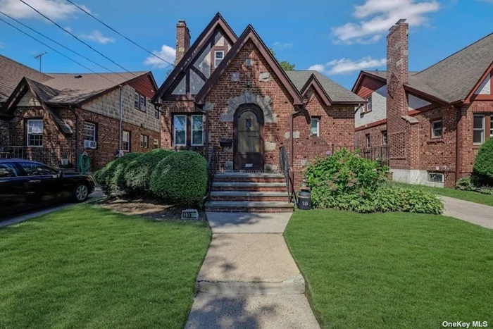 Lovely, Charming 4 Bedroom Brick Tudor Cape on tree-lined street, convenient to shops, school, park, bus and LIRR. Entrance Foyer, Living Room w/Fireplace, Formal Dining Room, EIK, Side Entrance and Driveway with 4 Car Parking. Wood Floors throughout.