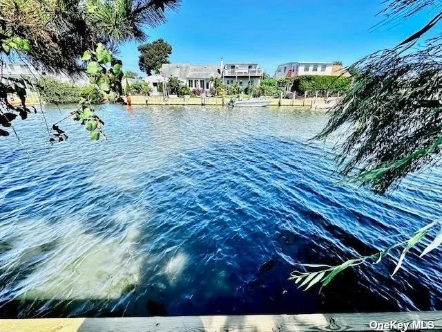 Charming Beach House on Deep Water Canal - Boasts 50 Ft. Updated Bulkhead with Breathtaking Views - Situated on Quiet Cul De Sac. Features 2 Bed. 1 and 1/2 Baths All Hardwood Floors, Open Floor Plan Great for Entertaining,  Two Sided Gas Fireplace in Living Room and Master Bedroom, Updated Baths, Separate Laundry Room, 3 New Ductless A/C and Heating Units, Large Deck, 2 Outdoor Sheds, Fenced Yard . Just Minutes to Smith Point Beach Fire Island, Great Fishing and Boating Awaits!