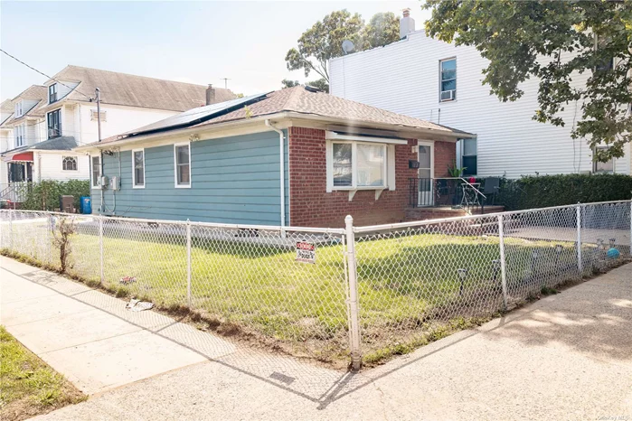 This charming corner property in South Ozone Park offers a blend of comfort and style. The home features an L-shaped living and dining room, providing a spacious and versatile area perfect for entertaining or relaxing. The updated kitchen boasts modern finishes and appliances that are less than a year old, ideal for culinary enthusiasts. There is a full bathroom on the main level for convenience. Roof less than 10 years old with leased solar panels. The full basement provides additional space for storage or potential expansion. 11 New Windows under a year. Boiler, Hot Water Tank & HVAC 3 years old. Located on a corner lot, this home enjoys an abundance of natural light and a pleasant neighborhood setting, making it an ideal choice for those seeking a cozy yet spacious living environment.