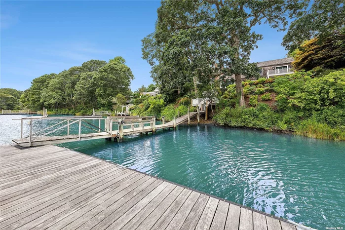 This stunning, fully renovated waterfront home features 4 bedrooms and 5 baths, with year-round blooming gardens. It boasts 113 feet of waterfront, a stone patio with a firepit, and a Gunite heated pool surrounded by lush landscaping for privacy. Perched on a bluff, winding stairs lead to a dock with 4.5 feet at low tide. The home includes two primary suites with water views, two guest suites, a living room with cathedral ceilings, a large kitchen and dining area, a full bath, and a media room. All rooms offer views of the stone patio and water. Ready for immediate move-in. Schedule a viewing soon.