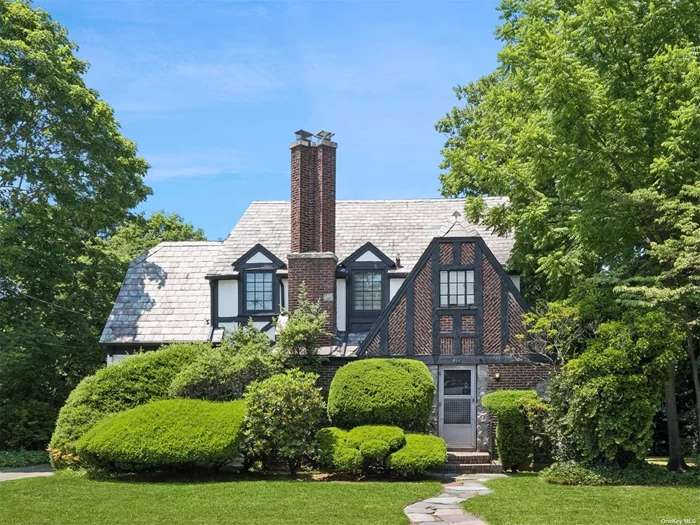 Charming Tudor home offering character and architecture with intricate details, woodwork, large windows throughout, and more. Welcoming you into a spacious and inviting foyer, half bath, leading into a large living room with large windows and a fireplace. An arched entryway into formal dining room featuring solid woodwork french doors leading into the den on one side and on the opposite a doorway flowing into an eat in kitchen, pantry, AND a second private back stairway leading up to the bonus room. Bonus room may used as a 5th bedroom, home office, gym, playroom, guest quarters. The upper floor features 4 bedrooms and 3 full baths, a primary en-suite with a full bathroom and closet space. Additionally a full unfinished walk up attic with lots of space, that may be turned into a bedroom or used for additional storage. Full basement with a side entrance that is partially finished. Spacious attached two car garage with a doorway into the kitchen. Backyard landscaped with a patio and garden area, perfect for entertaining.