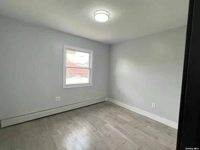 Newly Renovated three bedroom and two full bath apartment on the second floor , new floors new kitchen, new appliances and new bathroom. Close to transportation, easy access to Cross Island PKWY. Tenant pays heat, electric and cooking gas. Including one parking space. A must see!