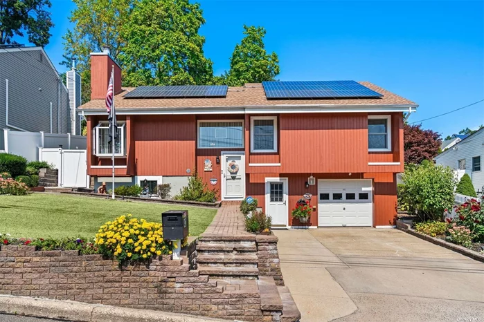 Follow your heart home! Impressive 5-bedroom, 3-bath Hi-Ranch on .14 acres in South Huntington! Pride of ownership shows throughout this well-maintained home. The home is bathed in natural light, with vaulted ceilings, raised panel doors, and double-pane windows, including some Andersons, adding to its appeal. The inviting living room, with its large windows, vaulted ceiling, and cozy fireplace, creates a warm and bright atmosphere. The updated eat-in kitchen boasts ceiling-high oak cabinets, granite countertops, and nearly new appliances, all under six years old. The dining room, perfect for gatherings, features sliding doors leading to the deck and backyard. The primary bedroom is a serene retreat, offering two double closets and an updated ensuite bathroom, updated just six years ago. The main level also includes two additional bedrooms, an updated full bath with a tub (6 years old), and access to a full attic via a pull-down staircase, providing ample storage. The lower level is equally impressive, featuring a spacious family room, two additional bedrooms, a full bath, a summer kitchen, and a separate entrance, offering the potential for an accessory apartment with proper permits. Additional amenities include a 1-car attached garage, laundry room, and utilities. The home is equipped with oil, hot water heat, in-ground sprinklers, and 200AMP electric service. Leased solar panels contribute to affordability by significantly reducing electric bills. Recent updates include the kitchen (6 years), both main floor baths (6 years), roof (5 years), oil tank (2 years), on-demand hot water heater (1 year), second refrigerator (3 years), and dryer (2 years). The private backyard has a deck and patio surrounded by beautiful perennial gardens, providing an ideal space for relaxation and entertaining. This beautiful home is ready to welcome you-make it yours today!