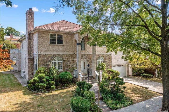 Welcome to this exquisite 6-bedroom, 3-bathroom residence in the Jamaica Estates neighborhood. This stunning all-brick home exudes timeless charm and sophistication, with a spacious and open floor plan designed for modern living. The inviting living room, anchored by a cozy wood-burning fireplace, offers a perfect setting for family gatherings or quiet evenings by the fire. The gourmet kitchen features sleek stainless steel appliances, including a dishwasher, and ample counter space, ideal for both everyday meals and entertaining guests. Throughout the home, split AC units provide efficient climate control, ensuring comfort in every season. Downstairs, the walk-out finished basement adds substantial living space, perfect for a family room, home office, or recreation area, and comes complete with a washer/dryer for ultimate convenience. Nestled on a large corner lot, the property showcases beautifully manicured front and back yards, ideal for outdoor relaxation, gardening, or hosting summer barbecues. The attached 2-car garage, along with a private driveway, provides plenty of parking and storage space. This impeccably maintained home is the perfect blend of comfort and convenience, offering a peaceful retreat in Queens, NY.