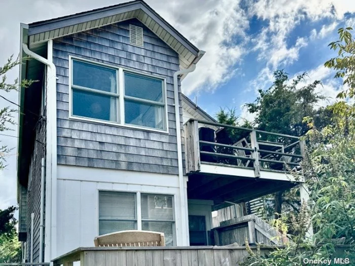 This unique light-filled two-family home is situated on the west end of Cherry Grove, and takes full advantage of the incredible views of the dune, the beach and the Atlantic Ocean. The top floor of the main duplex residence features a skylit kitchen and dining area, and a large, comfortable living space with a picture window looking out over the spacious front deck to the ocean beyond. A large primary bedroom with a luxurious en suite bathroom has its own private deck. Downstairs is another bedroom and bath, with an outdoor shower. The second residence is a one-bedroom apartment with its own private entrance. The compact kitchen is highly functional, with everything one needs to prepare delicious meals. The apartment also has its own private deck outside.