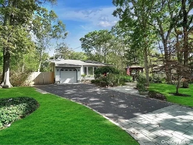 What elevates this three-bedroom, two-and-a-half-bath ranch to exceptional status is its superior condition and refined updates. The property boasts a comprehensive renovation, including a 2005 replacement of the roof, siding, windows, and skylights. Recent upgrades include a new oil tank (2018) and water tank (2020). The kitchen features a high-end Sub-Zero refrigerator, while the interior boasts freshly painted walls and expertly refinished hardwood floors. A 2023 ductless air conditioning system installation enhances the property. A fully renovated basement, accessible via an exterior entrance, boasts a wet bar, new bathroom, and egress windows. Additional amenities include a one-car garage, charming gazebo with electric, and expansive lot featuring privacy, new paver patio, new cesspools, and in-ground sprinklers. The electric was also updated with 200 amp service, further solidifying its appeal.