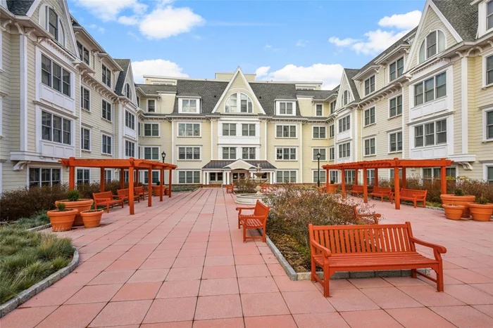 Step into this beautifully maintained 1, 200 sq. ft. third-floor apartment at the highly sought-after Sweetwater condominium, located in the vibrant heart of Mamaroneck Village. This inviting two-bedroom, two-bathroom home offers a peaceful retreat and is a quiet, corner unit with courtyard views and an abundance of natural light. The open-concept layout boasts hardwood floors and recessed lighting throughout, creating an airy and modern atmosphere. The spacious living room features a tray ceiling and a stunning custom built-in with bookcase, storage and television. This flows seamlessly into the dining area, perfect for both relaxation and entertaining. The contemporary kitchen is equipped with designer, stainless steel appliances, granite countertops, and a breakfast bar. The spacious primarybedroom offers a vaulted ceiling, a luxurious en-suite bathroom with double vanities, and a large walk-in closet. The unit is rounded out by a large second bedroom, a second full marble bath, and an in-unit Miele washer and dryer in a large storage utility closet. Residents of this exceptional building enjoy a wide range of amenities, including doormen with concierge service, a rooftop garden, a state-of-the-art fitness center, a community room with a kitchenette, a cozy library, and a garage with a dedicated parking spot. With the train, shops, restaurants, and parks just moments away, this home delivers unmatched convenience and a truly walkable lifestyle.