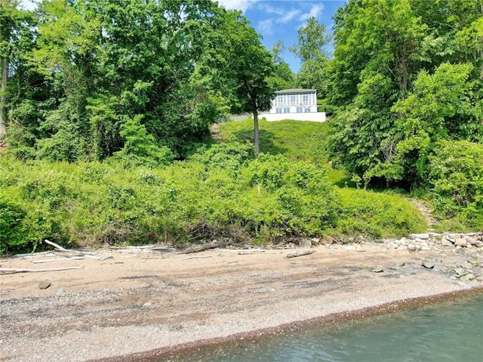 Moon River is an extraordinary Hudson Riverfront home in the iconic Snedens Landing neighborhood of Palisades, NY. It&rsquo;s snuggled by the Hudson River below, inspired by the cliffs of Palisades that surround it, and tapped by its own private beach below...it takes cues from nature and its surroundings. This early 20th century home has an extraordinary line of sight/view of the horizon. Impressive views of the Hudson River, treetops and the parklike surroundings, allows one to see for miles the minute one approaches and passes into the home. This gives residents and guests the feeling of calm and peacefulness as they enter. Moon River offers complete privacy and is located in a historic district that dates back before the Revolutionary War to the late 1600s and adjoins about 3, 000 acres of state parkland. There is no through traffic because there is only one road in and out of this community of about 100 homes. Moon River offers a luxury waterfront lifestyle, from a very quiet location, rich with provenance and is situated in a park like setting only 25 minutes from NYC - hard to believe! The structure is about 4, 300sf, with 5 bedrooms and 5 full and 2 half baths, including two primary bedrooms, each with a fireplace. There is also an oversized 2 car garage with lots of storage. Additional architectural features include wide board (very, very old) wood panels used in the ceiling and walls of the great room, along with massive/antique ceiling beams too. Two of the four fireplaces offer very deep/big fireboxes, ideal for building big fires. The home&rsquo;s stairwell features thick, solid, cedar stair treads, carved from trees that grew on the property, and old-style balustrades at the top landing, possibly from an old monastery in Europe. The home was built by legendary artist/resident, Mary Lawrence Tonetti, and designed by renowned architect, Eric Gugler, commissioned in America and Europe, and hired by FDR to redesign the oval office in the 1930s. At this same time Gugler designed Moon River he worked in the White House. He was friendly with architects McKim, Meade and White, in their day. Charles McKim was a frequent visitor to Snedens, where Eric Gugler also had a home. When M.M.W. shut its doors on Fifth Ave in NYC, McKim salvaged the original staircase from their office and used it in another property in Snedens Landing. Moon River was built for the Lowndes family. Moon River signifies the first night there&rsquo;s a full moon on the Hudson, after the forsythia bloom in early spring, where according to legend, the shad fish run plentiful in the Hudson, and fisherman would set their nets, supported by long poles, in the river to catch them. This tradition was practiced at this property for many years. The Snedens Landing neighborhood is unique because it&rsquo;s surrounded by the Hudson River on the east, Tallman State Park on the north, and Columbia University&rsquo;s Lamont Observatory and the Palisades Interstate Park on the south; about 3, 000 acres of parkland adjoin this location. Corbett Lane is an exclusive street with only three additional homes on it. Extremely private. Snedens Landing has a tennis association open to residents only for a nominal fee. Find your one of one. Discover Moon River.