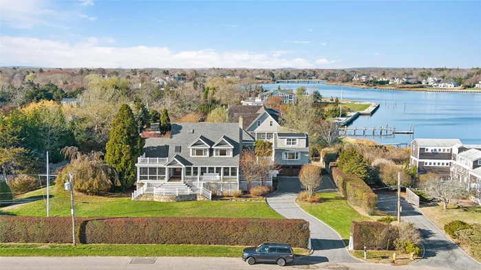 Nestled on a cul-de-sac in the estate section of Westhampton Beach, this elevated property boasts bay views from nearly every room. The first level features a living room with fireplace, a dining area, plus a formal dining room adjacent to the renovated kitchen. The kitchen is complete with granite countertops, custom cabinetry, an island, & stainless steel appliances. The heart of the home is a double-height great room with a fireplace & access to both a back deck & front screened-in porch. Upstairs, the master suite provides bay views, 3 closets, & an ensuite bath. An additional ensuite bedroom includes a private balcony, while 2 other bedrooms share a full hall bath. Additionally, the guest house features a living room, full kitchen, laundry, bedroom, & 2 full baths. The outdoor space offers an elevated deck, a pool bath, & a gunite pool, plus deeded access to a private neighborhood dock for boating, kayaking, etc. Property located just 1 mile from Main St. & Rogers Beach.